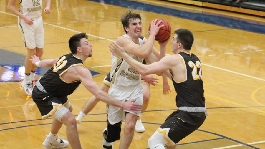 JCU Junior Ryan Berger (32) splits the Baldwin Wallace defenders & goes up for a layup in a game on Jan. 18. (JCU Sports Info)