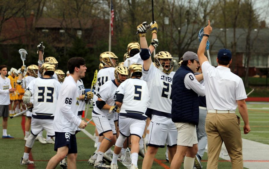 The John Carroll University men’s lacrosse team celebrates on the sideline after a goal against Baldwin Wallace in the OAC Championship at Don Shula Stadium.