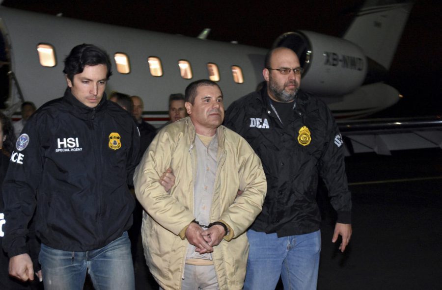 FILE - In this Jan. 19, 2017 file photo provided by U.S. law enforcement, authorities escort Joaquin El Chapo Guzman, center, from a plane to a waiting caravan of SUVs at Long Island MacArthur Airport, in Ronkonkoma, N.Y. U.S. District Judge Brian Cogan ruled Thursday, May 4, 2017, that Guzman needs to stay in solitary confinement at a New York City lockup to keep him from trying to control his drug-trafficking empire from behind bars. Cogan rejected a request by Guzman’s defense team to order him released from an ultrahigh-security wing of a jail in lower Manhattan and be allowed in the general inmate population and receive visitors. (U.S. law enforcement via AP, File)