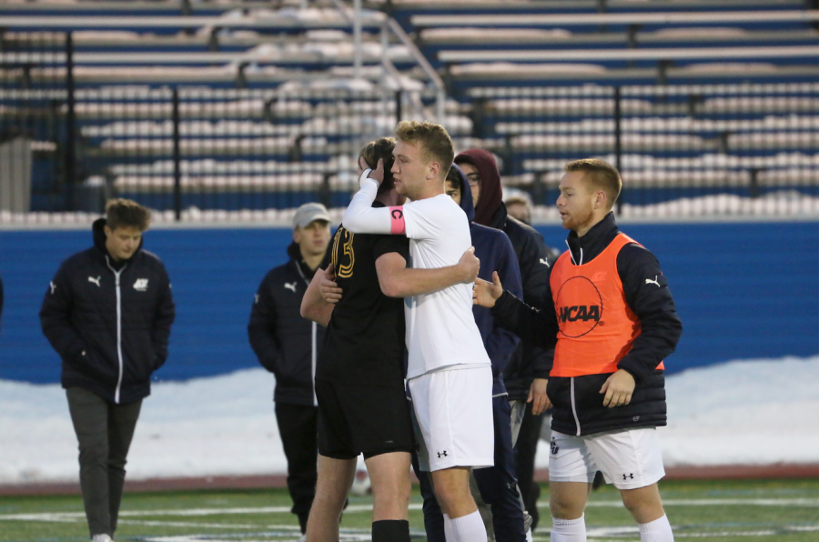 Senior Matt Nigro (white jersey) hugs an opponent from Centre following a season-ending loss on Sunday, Nov. 17, at Don Shula Stadium.