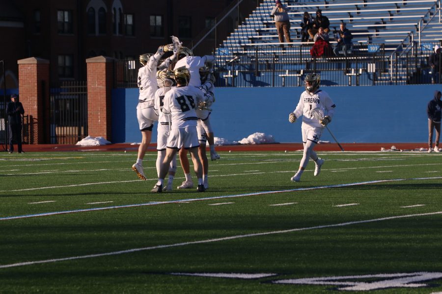 The+Blue+Streaks+celebrate+after+scoring+a+goal+against+Wittenberg+on+Feb.+22.+