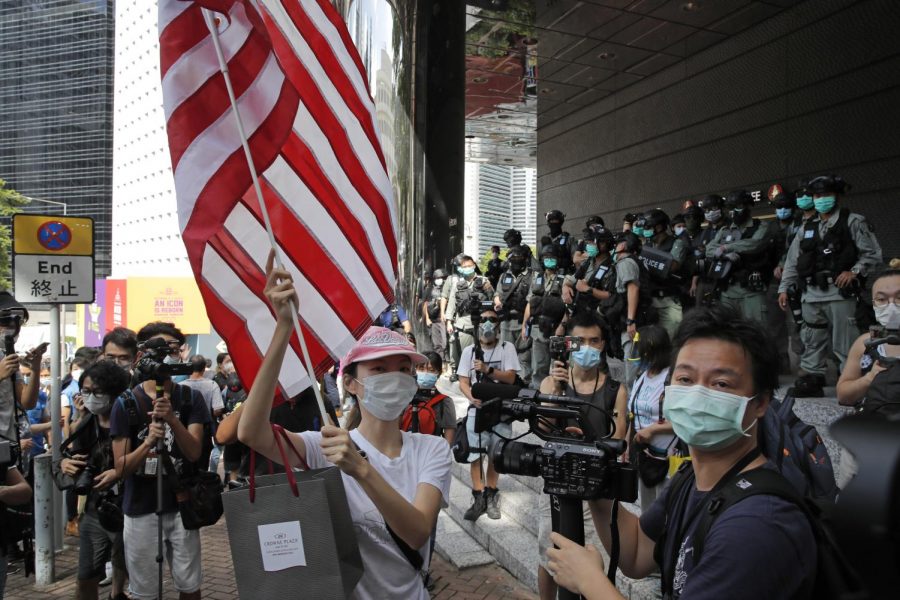 In this July 4, 2020, file photo, a woman carries an American flag during a protest outside the U.S. Consulate in Hong Kong. (AP Photo/Kin Cheung, File)