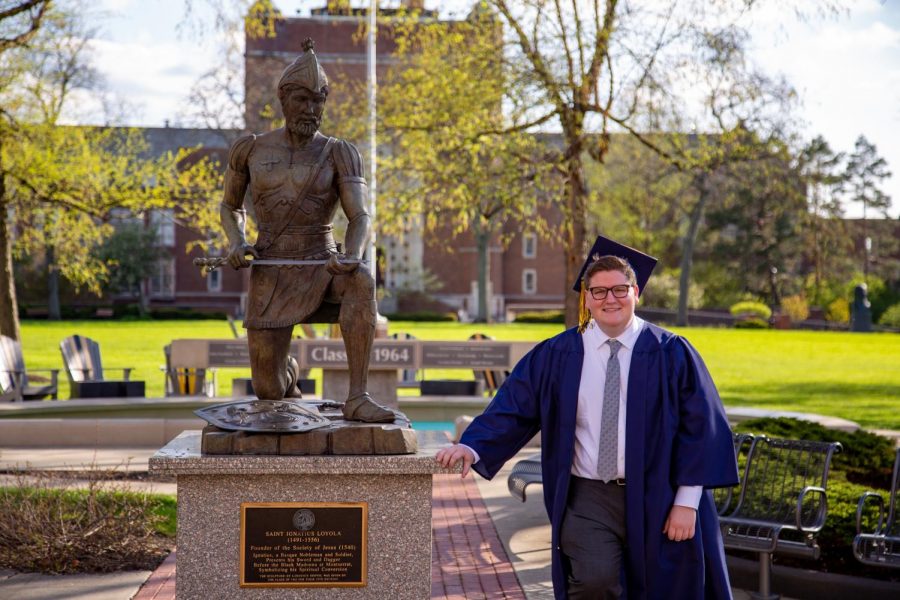 Class of 2020 senior Noah Paulsen poses by the iconic statue of St. Ignatius. 