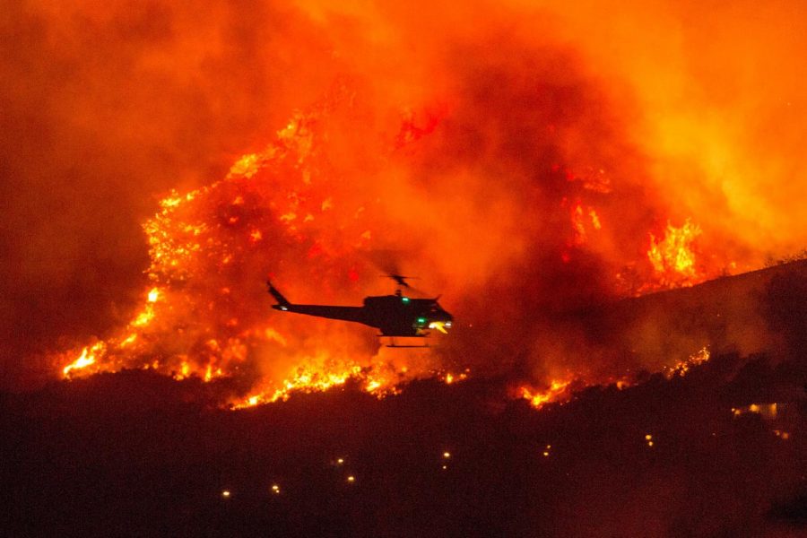 YUCAIPA, CALIF.  - In this Sept. 5 photo, a helicopter is seen preparing to drop water on a wildfire near Yucaipa, Calif., which was started by a pyrotechnical device used to reveal a baby’s gender. 