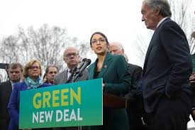 Representative Alexandria Ocasio-Cortez (center) speaks on the Green New Deal with Senator Ed Markey (right) in front of the Capitol Building in February 2019