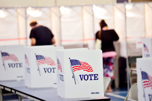 Voters cast their ballots as they conduct their civic duty. (Kristopher Radder/The Brattleboro Reformer via AP)