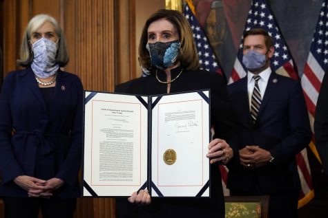 House Speaker Nancy Pelosi of Calif., displays the signed article of impeachment against President Donald Trump in an engrossment ceremony before transmission to the Senate for trial on Capitol Hill, in Washington, Wednesday, Jan. 13, 2021. (AP Photo/Alex Brandon)