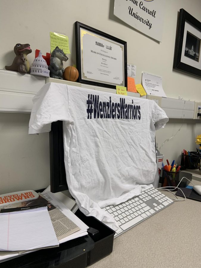 This desk is frequently used by Kyle Kelly, sports editor. This shirt honors the late Chris Wenzler, former director of Sports Information.
(Photo by Aiden Keenan).
