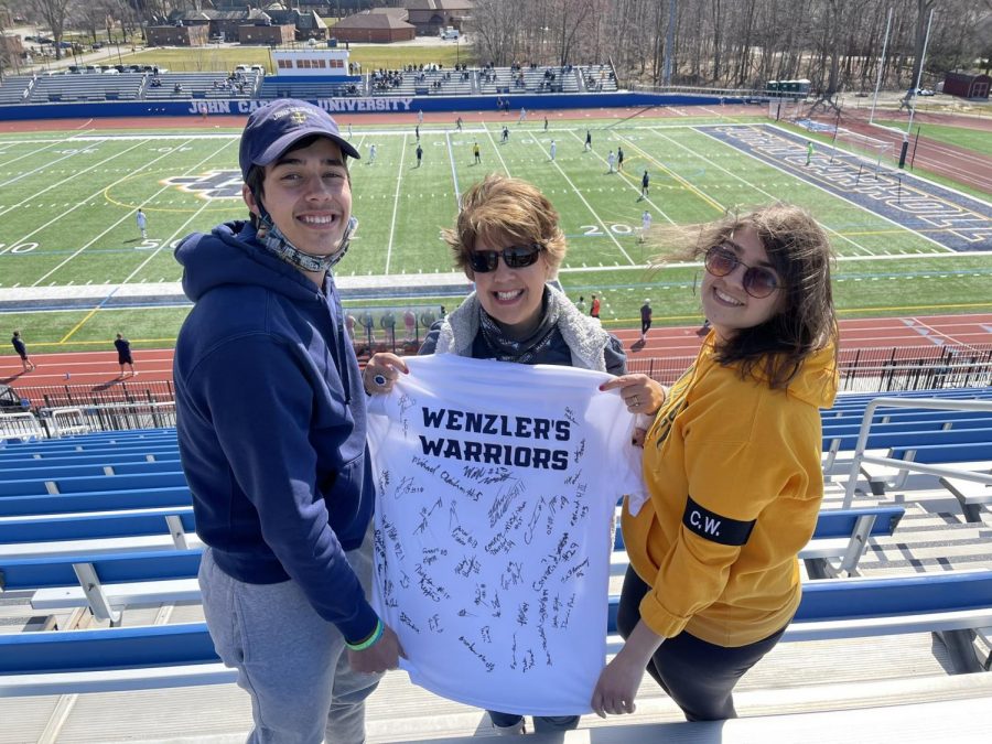 Oliver Wenzler (left), Melissa Wenzler (middle), Madeline Wenzler (right) hold up a t-shirt that was signed by the JCU Mens Soccer Team at Don Shula Stadium on Sunday, March 21, 2021. 