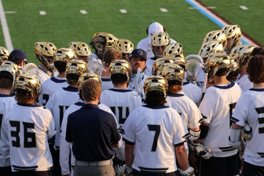 Joe Rautenstrauch (middle with hat on) talks to his team before a rivalry matchup with Baldwin Wallace at Don Shula Stadium on April 7, 2021.