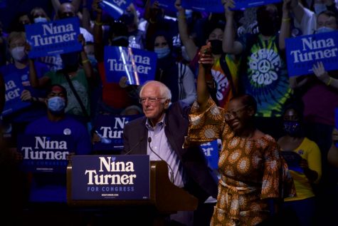 Sen. Sanders and Nina Turner hold their hands in the air on stage.
(Photo by Aiden Keenan).