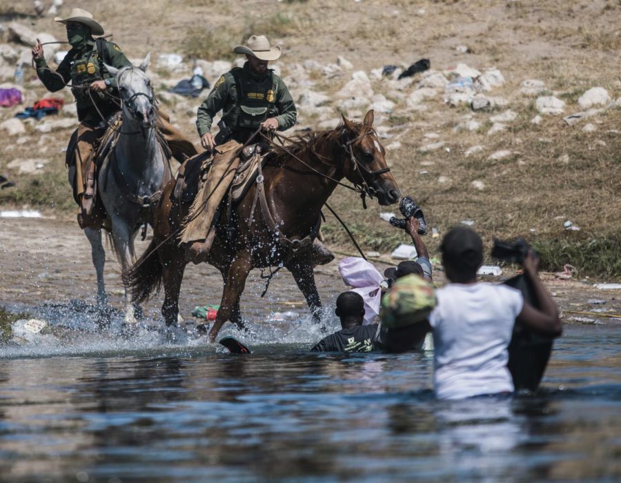 In this Sept. 19, 2021, file photo, U.S. Customs and Border Protection mounted officers attempt to contain migrants as they cross the Rio Grande from Ciudad Acuña, Mexico, into Del Rio, Texas. 