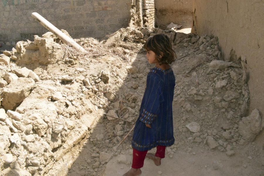 A girl looks at a damaged house following an earthquake in Harnai, about 100 kilometers (60 miles) east of Quetta, Pakistan, Thursday, Oct. 7, 2021.