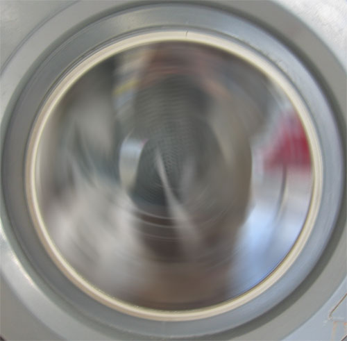 A public washing machine spinning in motion.