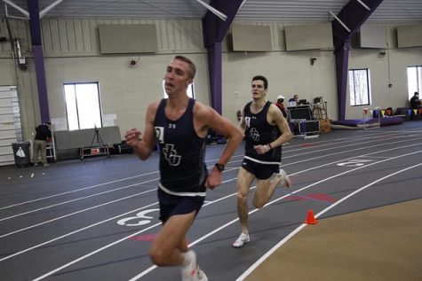 Alex Phillip running in an indoor track and field race last season. 