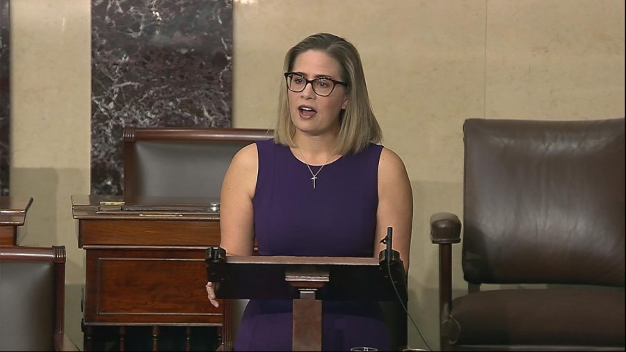 In this image from Senate Television, Sen. Kyrsten Sinema, D-Ariz., speaks on the floor of the U.S. Senate on Thursday, Jan. 13, 2022. President Joe Biden is set to meet privately with Senate Democrats at the Capitol, a visit intended to deliver a jolt to the party’s long-stalled voting and elections legislation. Before he arrived Sinema blunted the bill’s chances further, declaring she could not support a “short sighted” rules change to get past a Republican blockade.