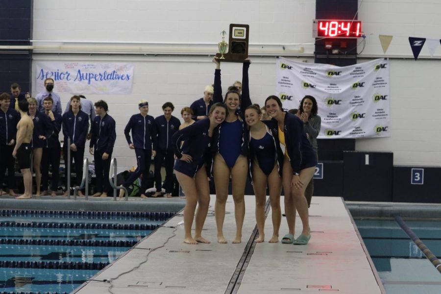 John Carroll University Womens Swimming and Diving senior class holding the OAC Championship trophy. 