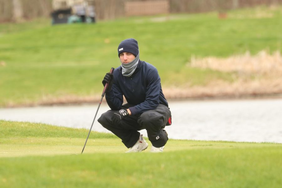 Grant Lumley reads the green as he faces winter weather conditions on Monday.