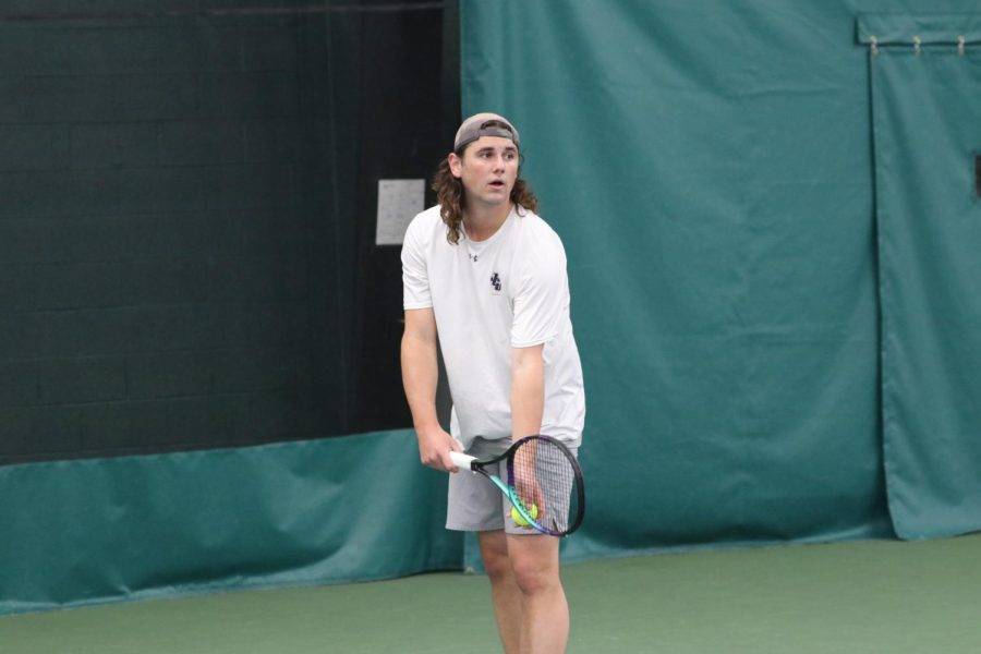 Logan Langovsky gets ready to serve indoors as he furthers his success for the Blue and Gold.