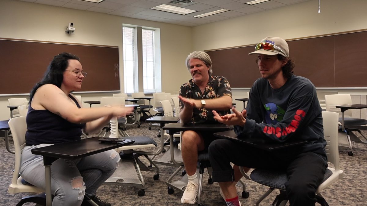 Editor-in-Chief Laken Kincaid sits with the band 3OH!3 in a classroom of JCU.