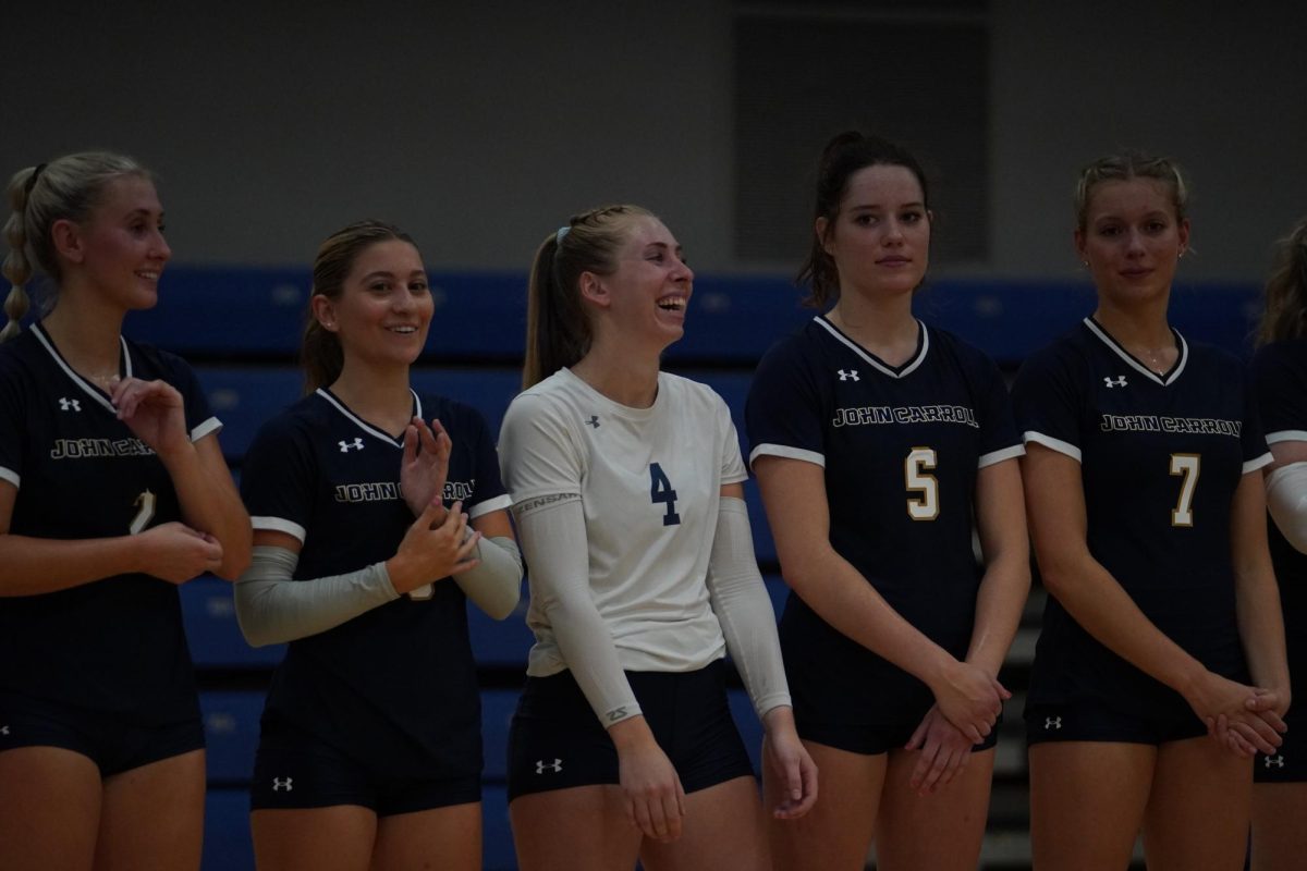MacDonald smiles while being introduced before a volleyball game on campus
