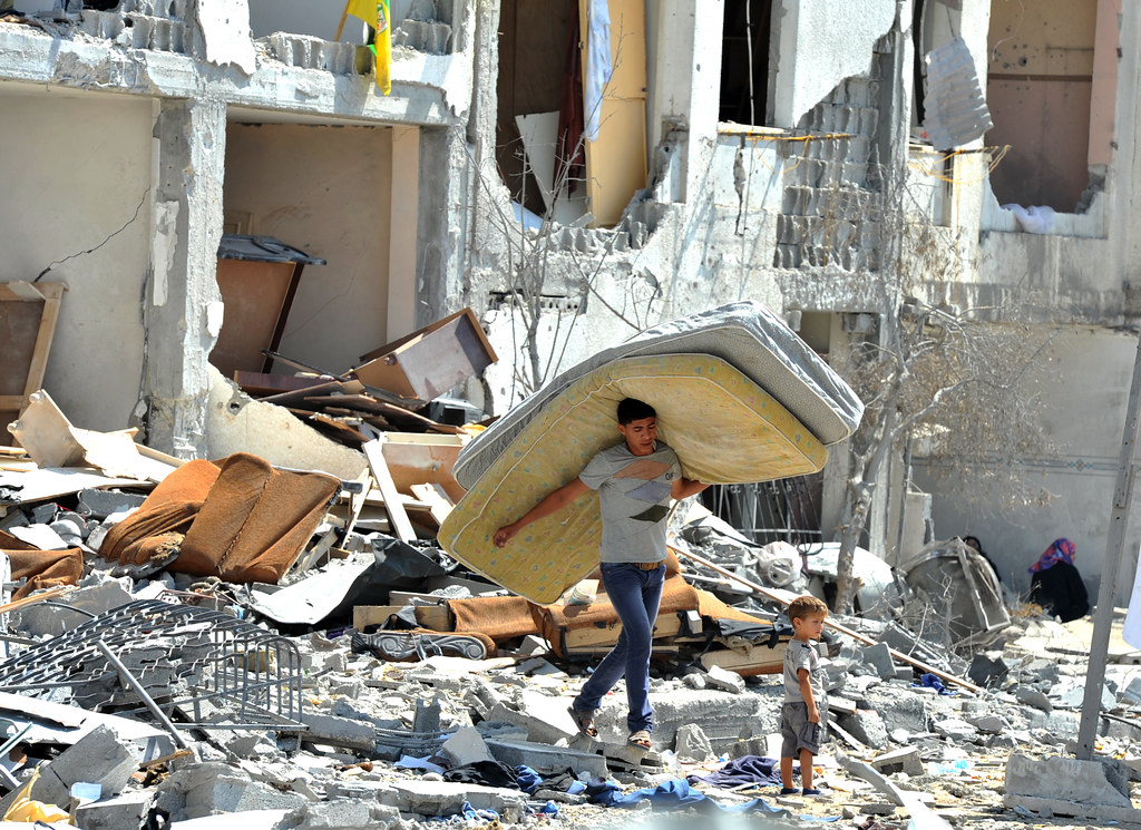 A+Palestinian+searches+through+rubble+of+his+destroyed+home+hit+by+Israeli+strikes+in+Towers+Al-andaa+-+the+northern+Gaza+Strip.