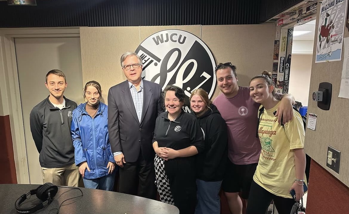 Editor-in-Chief+Laken+Kincaid+smiles+with+former+NBC+correspondent+Pete+Williams+and+the+crew+at+WJCU.