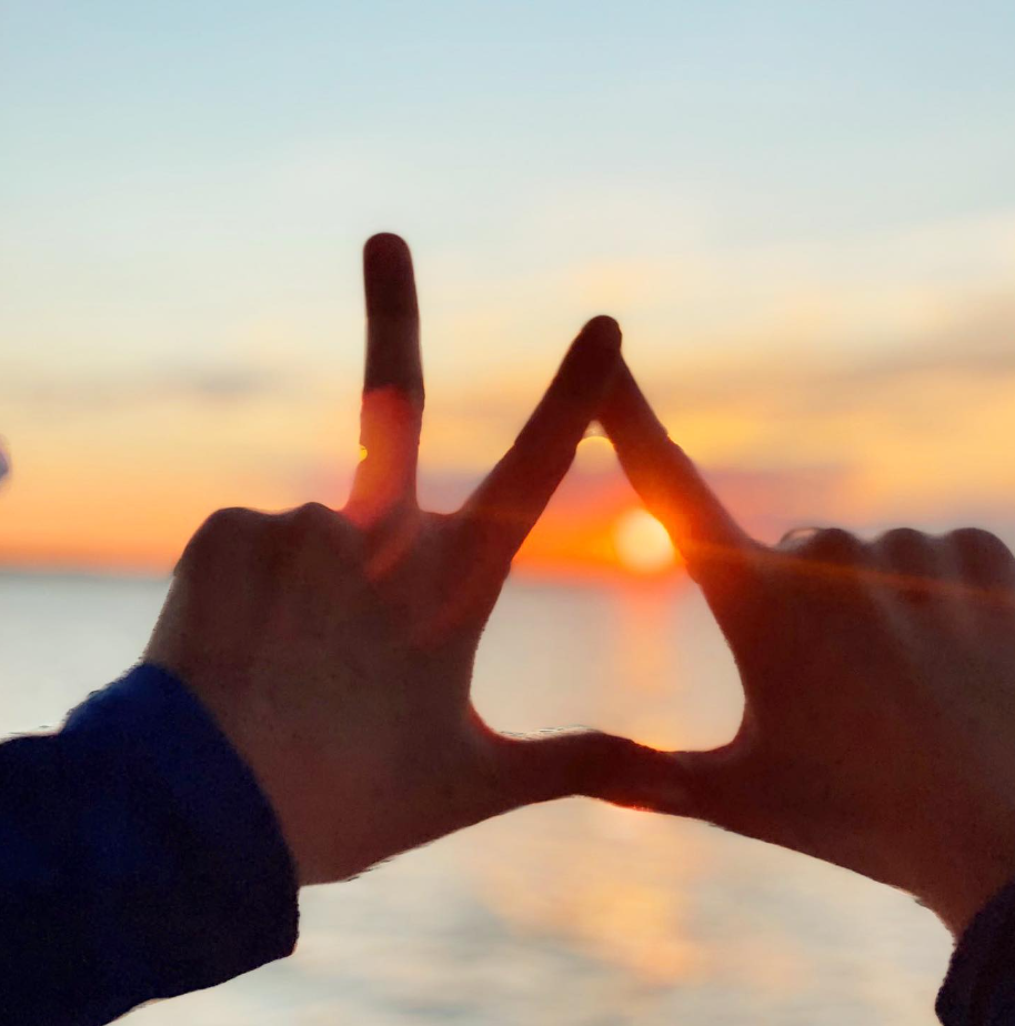 A pose featuring the letters of Kappa Delta in front of a sunset. 