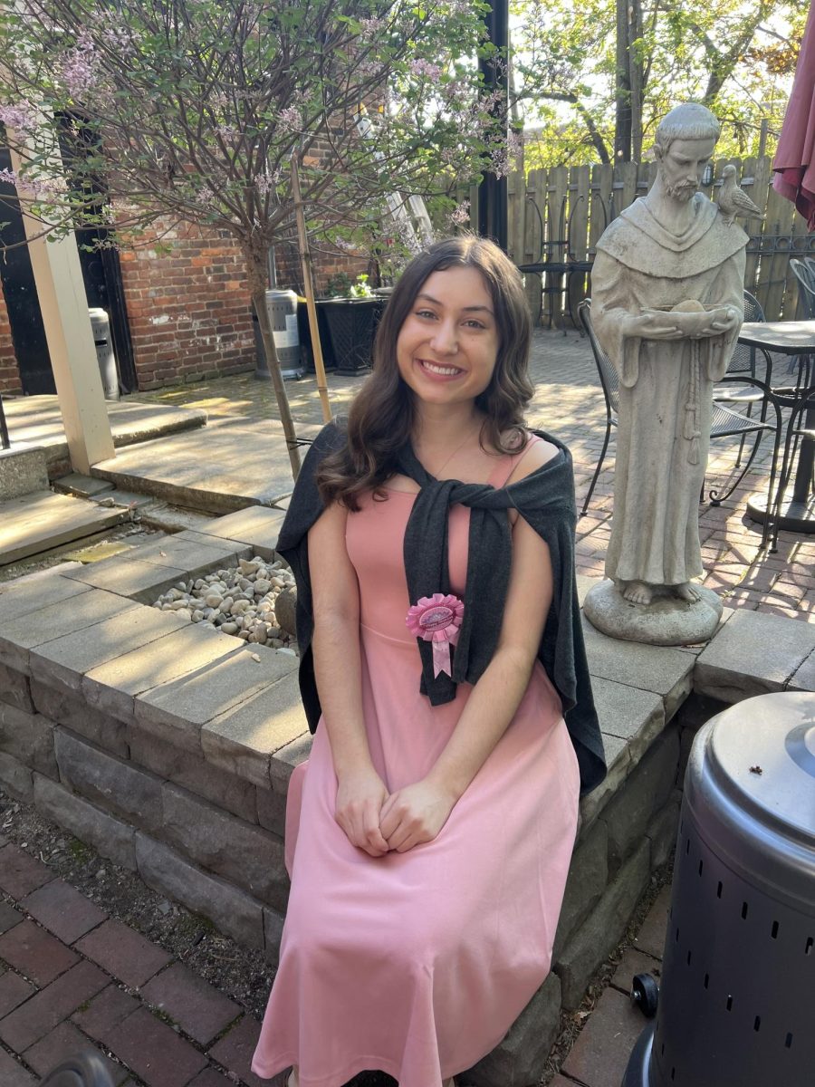 A newly 21-year-old Alissa Van Dress sits in front of a statue of St. Francis at Guarinos in Little Italy.