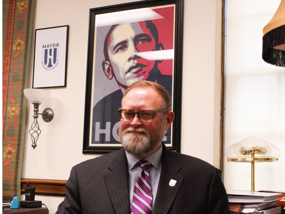 University Heights Mayor Michael Dylan Brennan sitting in front of his portrait political role model, Barack Obama