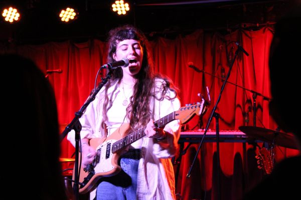 Cece Coakley singing with passion on stage at The Grog Shop. 