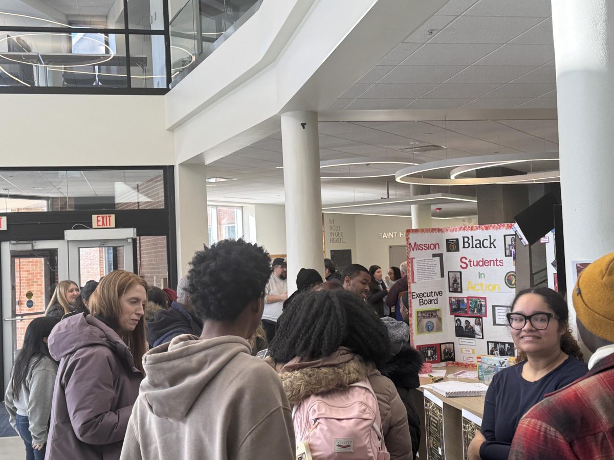 Students and staff gathering around to learn more about Black History Month.
