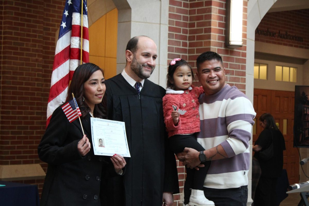 Shereenata Deocareza, left, celebrates her citizenship with her daughter, Sheana Cailey, 5, and husband, Carlito, right. Next to Deocareza is U.S. District Court Judge J. Philip Calabrese.
