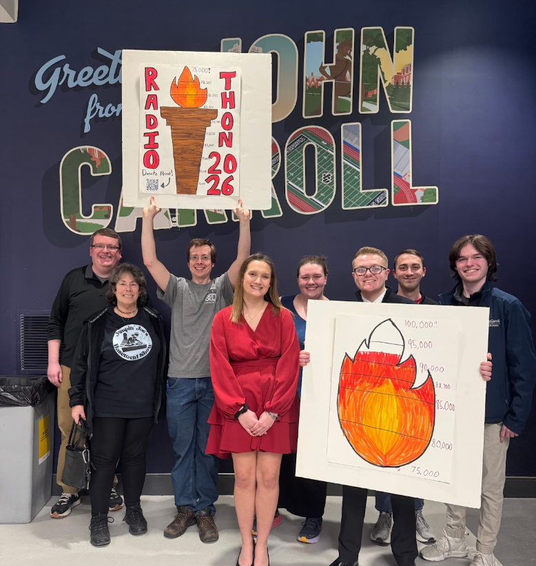 Members of the WJCU community posing with a torch and ambition during Radiothon.