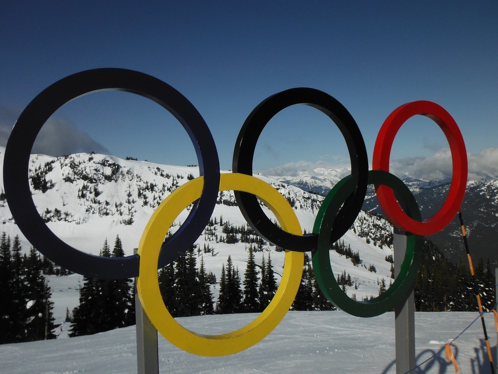 The Olympic rings displayed in the snow on a ski slope. 