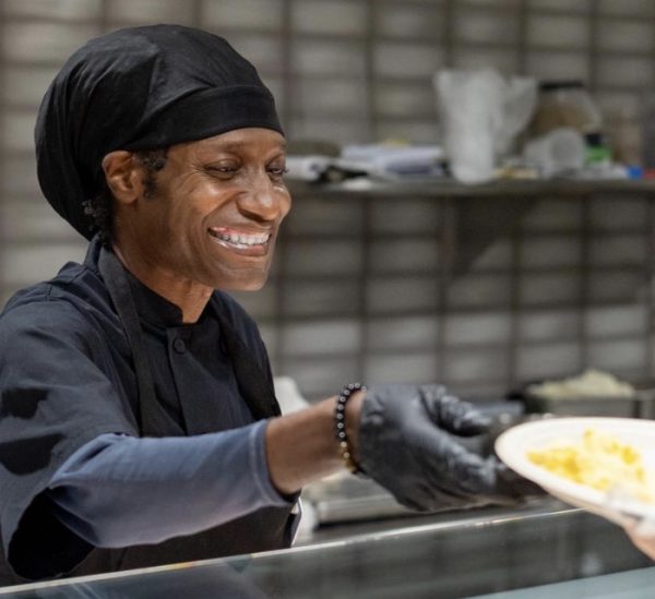 Deon Sankey serving fresh food with a fresh and energized smile.